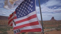 American Flag and Monument Valley, Towering Sandstone Buttes on Navajo Tribal on Arizona - Utah Border USA