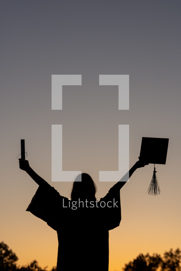 a graduation senior celebrating at sunset