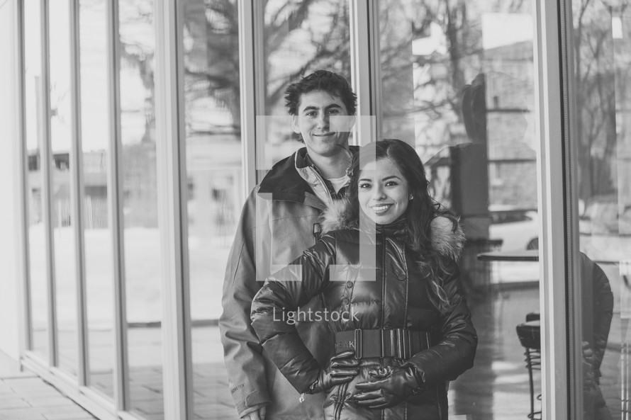 portrait of a couple standing in front of shop windows 