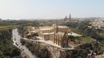 4k aerial drone footage circling the Church Ghajnsielem Parish in the Mediterranean town of Mgarr - Gozo, Malta