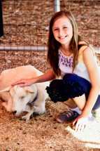 a child petting a goat at a petting zoo 
