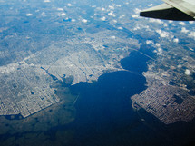 view of a city below out a plane window 