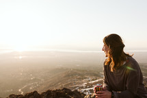 Woman holding a beer while on a sunset hike