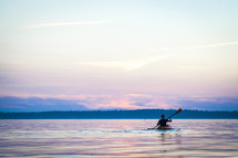 Rower in the water at dusk.