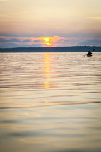 Rower in the water at sunset.