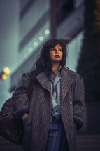 a woman walking in a city in a heavy coat 