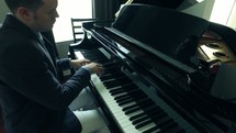 a man playing a grand piano 