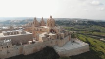 Mdina city outside city walls, revealing the Cathedral of Saint Paul  - Low angle point of interest Aerial shot