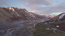 Fly over river delta in rainbow mountains in epic Icelandic nature
