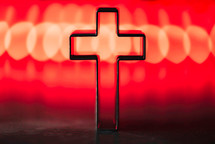 Silhouette of christian cross on soft bokeh lights background. Copy space. 