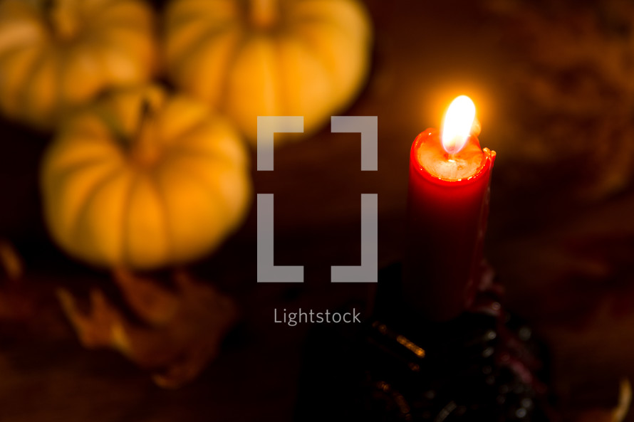 a candle with fall pumpkins