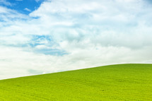 Background of green field with blue sky in Italy
