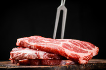 Raw pork steak on a stone board. On a black background. High quality photo