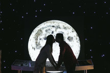 couple kissing in front of the moon