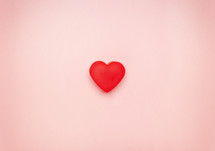 Red heart in the center of a pink background.