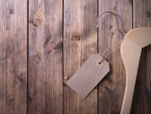 wood hanger with a tag on a wood floor 