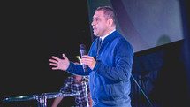 a preacher on stage holding a microphone 