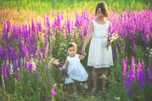sisters walking in a field of flowers 