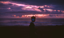 silhouette of a man listening to headphones on a beach at sunset 