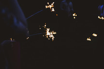 people holding sparklers outdoors 