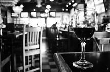Glass of wine on corner of a bar.