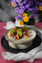 Figs on a plate with purple flowers