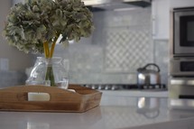 wooden tray on a quartz countertop in a kitchen 