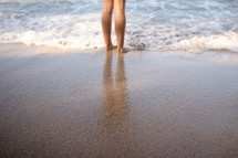 legs standing in the ocean 