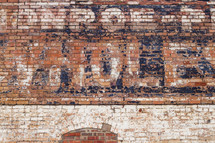 bricked in window and old words on a brick wall of an old warehouse 
