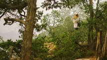 woman in a forest taking a picture 