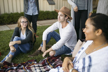 friends sitting on a blanket in the grass