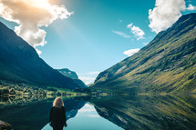 a woman looking out at the view of a mountain lake 