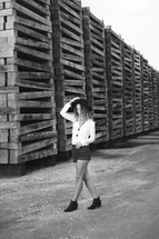 woman posing in front of stacked pallets 