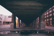 puddle on a road under an overpass 