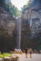 people gathered at a viewing site to watch a waterfall 