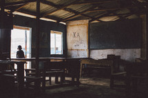 child in an empty rundown classroom 