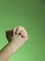 praying hands against a green background 