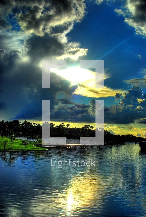 sunlight in the clouds over tropical beach and dock 