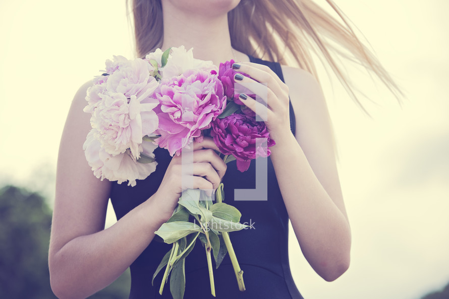 torso of a young woman holding flowers 