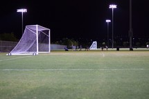 soccer fields at night with city lights in the background 