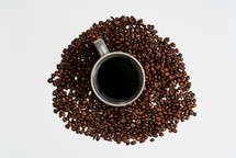 Coffee mug in the middle of coffee beans