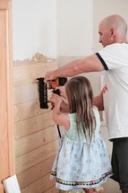 father and daughter using a nail gun to put up shiplap