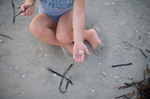 girl child sitting on a beach 