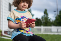 toddler girl holding a cellphone 