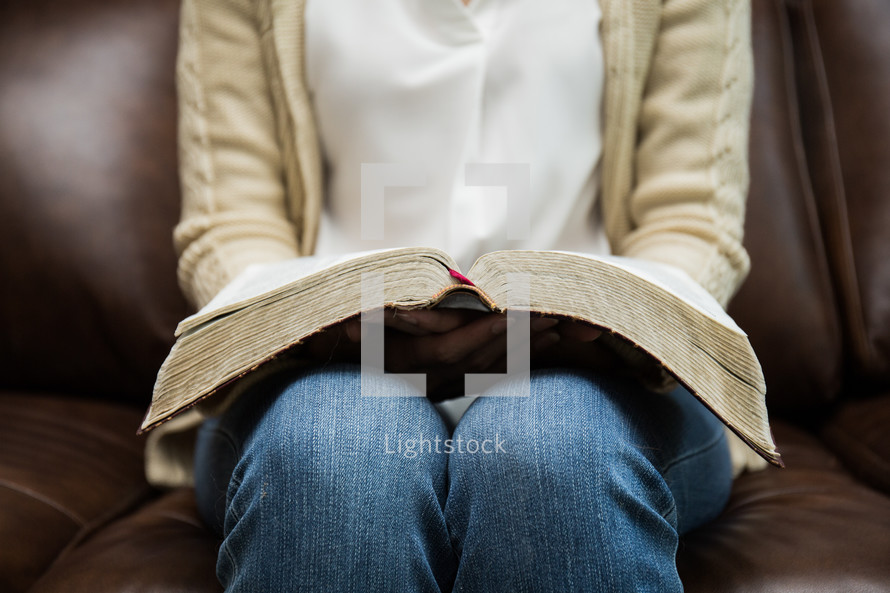 a woman reading with a Bible in her lap 