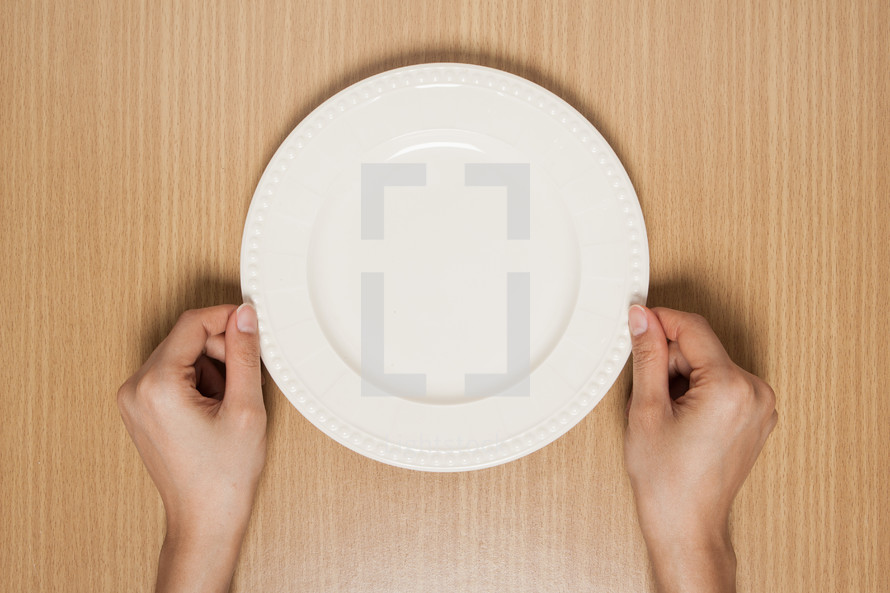 hands holding an empty plate 