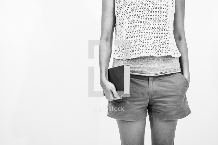 torso of a young woman holding a Bible 