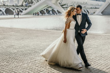 bride and groom walking through a city 