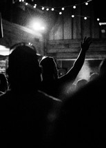 people with raised hands standing during a worship service 