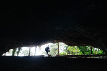 view of a person standing at the mouth of a cave